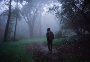 man walking down dark path
